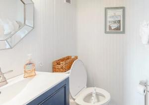 a white bathroom with a toilet and a sink at Dunescape Villas by TO in Atlantic Beach
