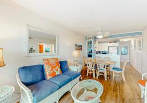 a living room with a blue couch and a table at Dunescape Villas by TO in Atlantic Beach