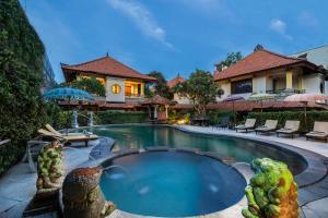 a house with a swimming pool with two parrots in it at Villa at Royal Tunjung Bali in Seminyak