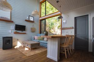 a living room with a blue couch and a table at Cala Melí in Puerto Varas