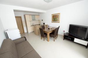 a living room with a couch and a table and a television at Apartments by the sea Promajna, Makarska - 17160 in Promajna +15 photos