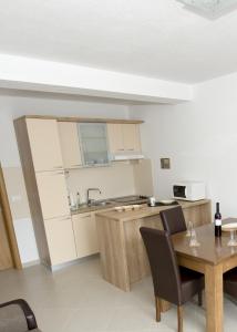 a kitchen with a wooden table and a table and chairs at Apartments by the sea Promajna, Makarska - 17160 in Promajna