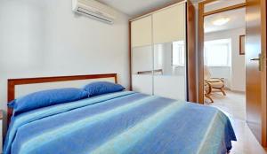 a bedroom with a blue bed and a large mirror at Apartments by the sea Sumartin, Brac - 17090 in Sumartin