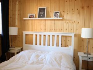 Schlafzimmer mit einem weißen Bett und Holzwänden in der Unterkunft Chalet Chamrousse, 5 pièces, 8 personnes - FR-1-549-105 in Chamrousse