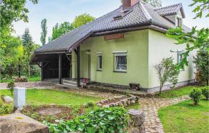 a small green and white house in a yard at Holiday Home Nowe Warpno Ul Szczecinska in Nowe Warpno