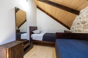 1 Schlafzimmer mit 2 Betten und einer Steinmauer in der Unterkunft Family friendly house with a swimming pool Bogatic, Krka - 17168 in Oklaj