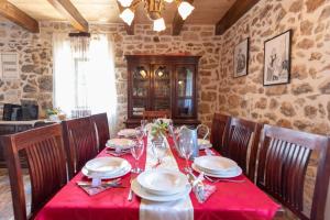 einen Esstisch mit einem roten Tischtuch in der Unterkunft Family friendly house with a swimming pool Bogatic, Krka - 17168 in Oklaj