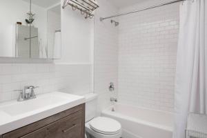 a white bathroom with a sink and a toilet at The Exquisite Venice Beach Bungalow with Garden in Los Angeles