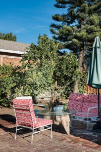 two chairs and a table and an umbrella on a patio at The Exquisite Venice Beach Bungalow with Garden in Los Angeles