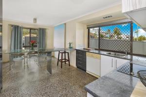 a kitchen with a table and a large window at NAROO7- PRIME, CENTRE OF MOOLOOLABA LOCATION in Mooloolaba