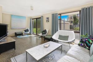 a living room with a couch and a tv at NAROO7- PRIME, CENTRE OF MOOLOOLABA LOCATION in Mooloolaba