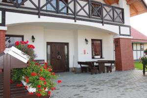 a house with a patio with a table and flowers at Storczykowe Wzgórze in Paszowice