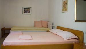 een slaapkamer met 2 bedden met roze en groene lakens bij Apartments and rooms by the sea Molunat, Dubrovnik - 17143 in Gruda