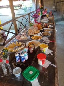 a long table with food and drinks on it at Pousada Bela Vista Maricá in Maricá