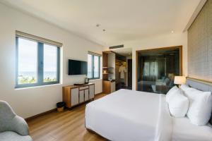 sypialnia z białym łóżkiem i kanapą w obiekcie The Tahiti Beach Hotel w Duong Dong