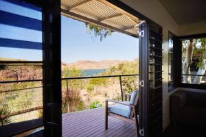 a room with a balcony with a chair and a view at Discovery Resorts - Lake Argyle 