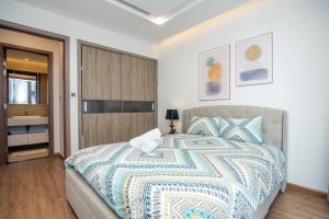 1 dormitorio con 1 cama con colcha colorida en Shendo Vinhomes Metropolis, en Hanói