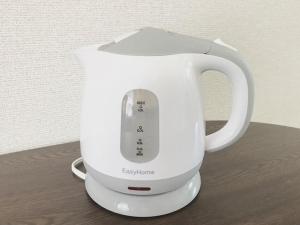 una cafetera blanca con mando a distancia en Best Room In Kawagoe 3, en Kawagoe