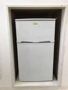 a white refrigerator sitting inside of a room at Best Room In Kawagoe 3 in Kawagoe