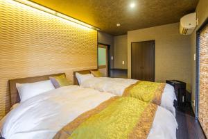 duas camas num quarto de hotel com em Hamabe no Yado Asahiya em Himi