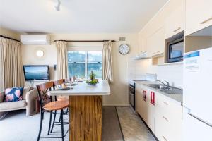 a kitchen and living room with a table and chairs at Sunnie Belle, 2,3 Victoria Parade - Unit with water views and air conditioning in Nelson Bay