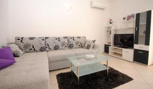a living room with a couch and a tv at Apartments with a parking space Rogoznica - 17106 in Rogoznica
