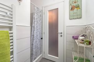 a bathroom with a door and a walk in shower at Seaside holiday house Artatore, Losinj - 17102 in Čunski