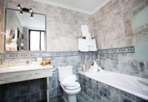 a bathroom with a tub, toilet and sink at Hotel & Spa María Manuela in Onís