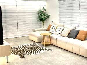 sala de estar con sofá blanco y alfombra de cebra en Jabez Homestay, en Yilan City