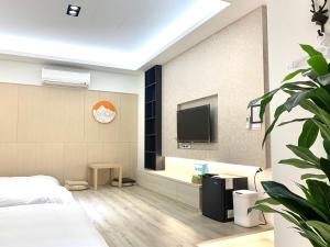 a bedroom with a bed and a tv on a wall at Jabez Homestay in Yilan City