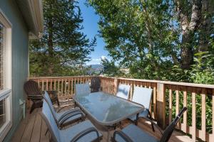 un patio con mesa y sillas en una terraza en Twin Rivers Vasquez 3 by Stay Winter Park en Fraser