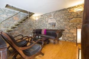 a salon with chairs and a stone wall at Family friendly house with a swimming pool Bajcici, Krk - 17293 in Malinska