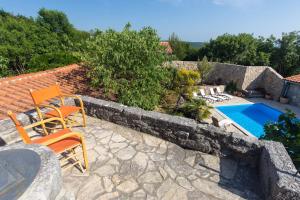 a patio with two chairs and a swimming pool at Family friendly house with a swimming pool Bajcici, Krk - 17293 in Malinska