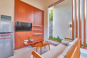 a living room with a couch and a television at Villa Casa Natura 15 - 2 BRV with private pool 15 mins to Ubud in Ubud