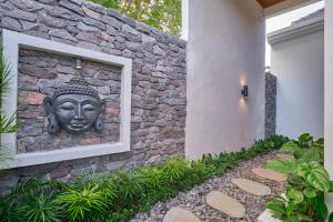 a stone wall with a statue of a head on it at Villa Casa Natura 15 - 2 BRV with private pool 15 mins to Ubud in Ubud