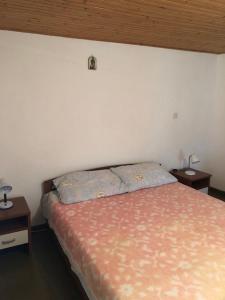 ein Schlafzimmer mit einem Bett und zwei Nachttischen in der Unterkunft Apartments by the sea Susak, Losinj - 17302 in Susak