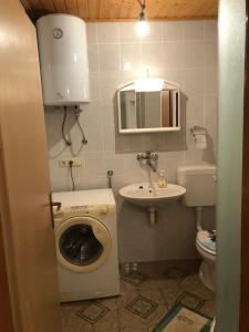 a small bathroom with a washing machine and a sink at Apartments by the sea Susak, Losinj - 17302 in Susak