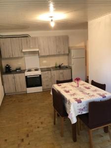 eine Küche mit einem Tisch und eine Küche mit einem weißen Kühlschrank in der Unterkunft Apartments by the sea Susak, Losinj - 17302 in Susak