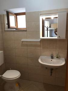 ein Bad mit einem WC, einem Waschbecken und einem Fenster in der Unterkunft Apartments with WiFi Susak, Losinj - 17303 in Susak