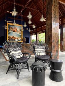 a room with two chairs and a painting on the wall at La Reserve 1785 Canggu Beach in Canggu