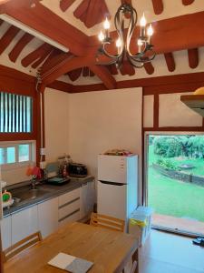 uma cozinha com uma mesa e um frigorífico branco em Big Blue House em Boseong