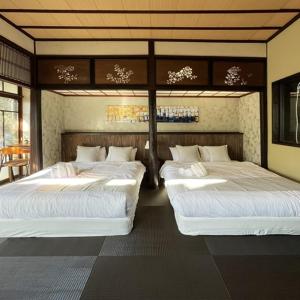 um quarto com três camas num quarto em KIYOMORI em Hatsukaichi