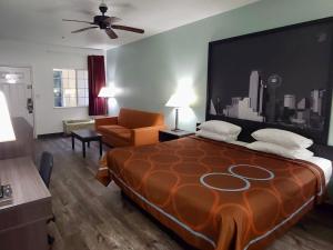 a hotel room with a large bed and a couch at Super 8 by Wyndham Forney/East Dallas in Forney