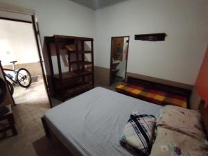 a bedroom with a bed and a chair and a mirror at Hostel Mucugê in Mucugê