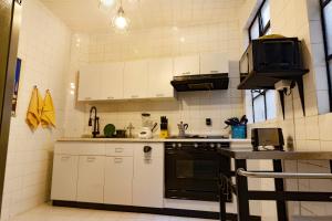 una cocina con armarios blancos y horno negro en FABULOSO APARTAMENTO 2BR / 2B POLANCO 403, en Ciudad de México