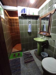een badkamer met een wastafel, een toilet en een spiegel bij Hostel Mucugê in Mucugê