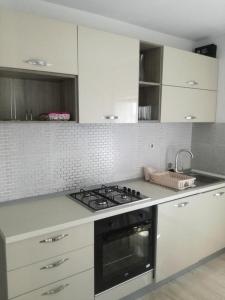 a kitchen with white cabinets and a stove top oven at Apartments by the sea Zatoglav, Rogoznica - 17321 in Rogoznica