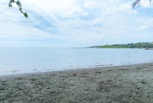 une plage avec l'océan en arrière-plan dans l'établissement Erojo's Beach Resort, à Sindangan