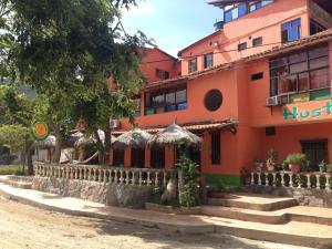 an orange building with stairs in front of it at Hostal Pelikan Taganga in Taganga