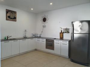 a kitchen with white cabinets and a stainless steel refrigerator at Hilltop Sea view , Boca Gentil in Willemstad